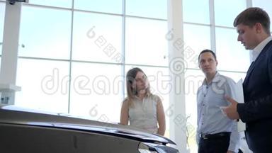 汽车经销商，购买汽车的幸福家庭，车展经销商，展厅，汽车销售商展示消费者新车，